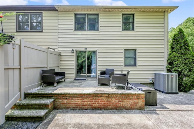 rear view of house featuring fence, central AC unit, and a patio area
