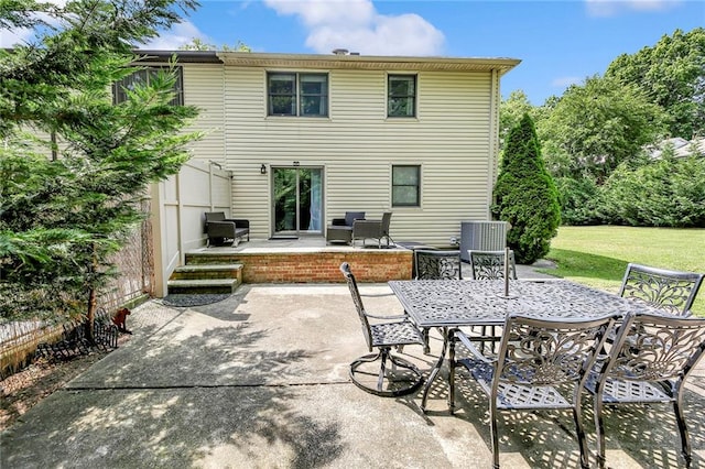 rear view of house with outdoor dining area, a lawn, central air condition unit, and a patio