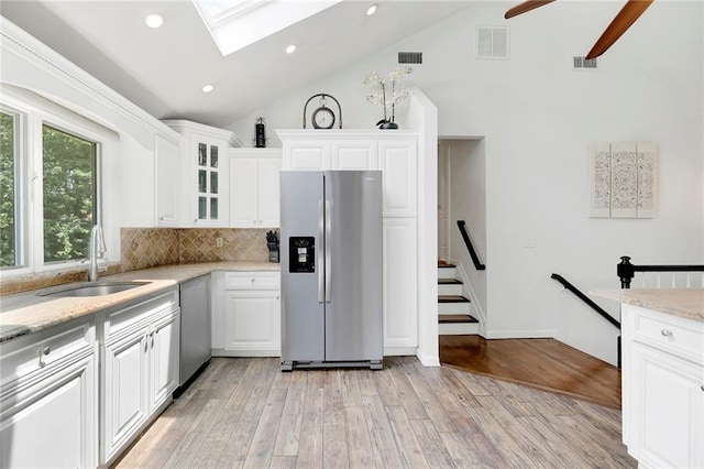 kitchen with visible vents, decorative backsplash, light wood-style floors, a sink, and appliances with stainless steel finishes