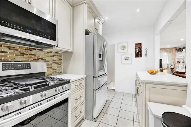 kitchen featuring recessed lighting, appliances with stainless steel finishes, light tile patterned floors, decorative backsplash, and baseboards
