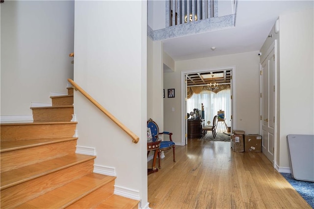 interior space featuring baseboards, a high ceiling, and wood finished floors