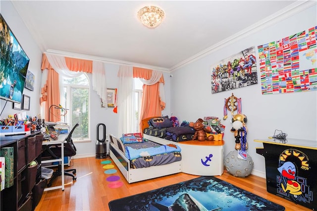 bedroom featuring crown molding, baseboards, and wood finished floors