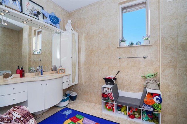 bathroom with tile patterned floors, tile walls, and vanity