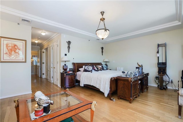 bedroom with crown molding, light wood-style flooring, baseboards, and visible vents