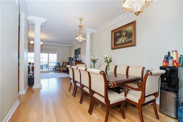 dining area with baseboards, light wood finished floors, ornamental molding, and ornate columns