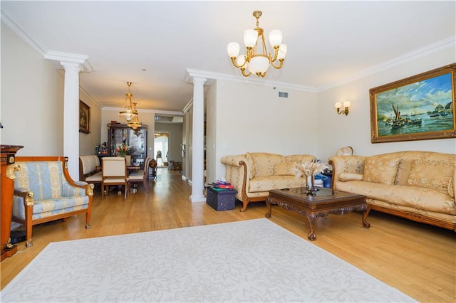 living area with wood finished floors, visible vents, and ornate columns