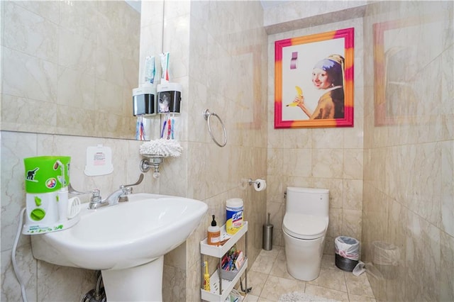 bathroom featuring toilet, tile walls, and tile patterned flooring