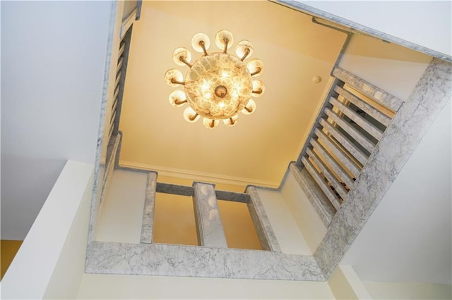 staircase with a notable chandelier