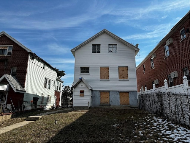 rear view of house with fence and a wall mounted air conditioner