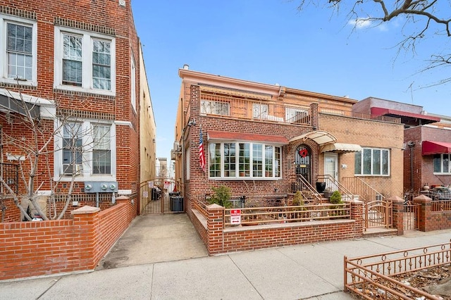 view of front facade featuring fence, brick siding, and a gate