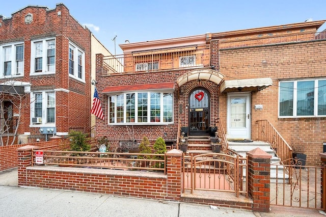 view of front of home with a gate, cooling unit, brick siding, and a fenced front yard