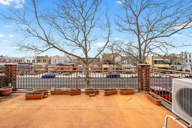 view of patio / terrace featuring a balcony, ac unit, and a residential view