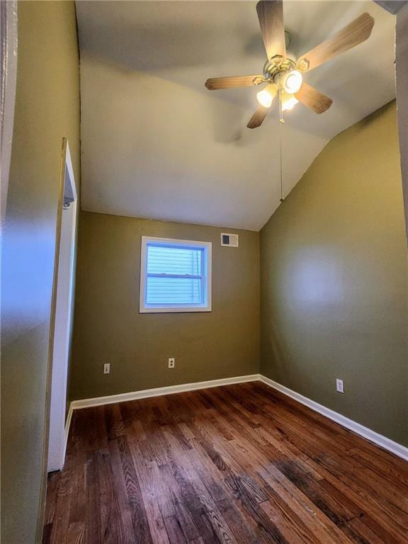 unfurnished room with visible vents, baseboards, lofted ceiling, and wood finished floors