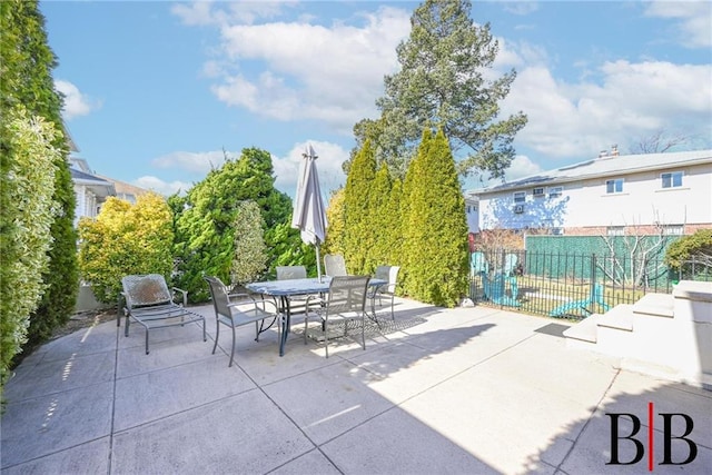 view of patio with outdoor dining space and fence