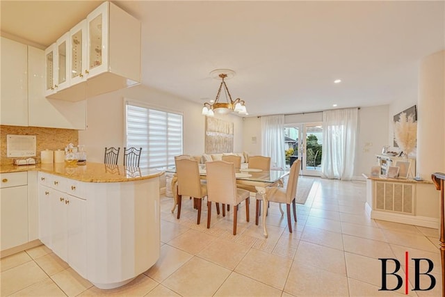 interior space featuring white cabinets, light tile patterned flooring, glass insert cabinets, and visible vents