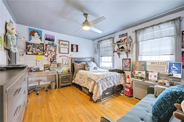 bedroom featuring ornamental molding, cooling unit, light wood finished floors, and ceiling fan