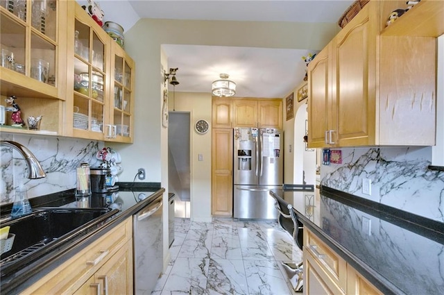 kitchen with marble finish floor, light brown cabinets, glass insert cabinets, a sink, and stainless steel appliances