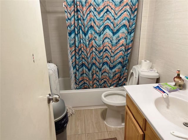 bathroom with tile walls, toilet, shower / bath combo, wood finished floors, and vanity