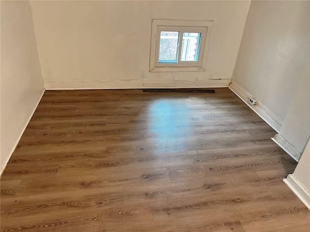 unfurnished room featuring baseboards and wood finished floors