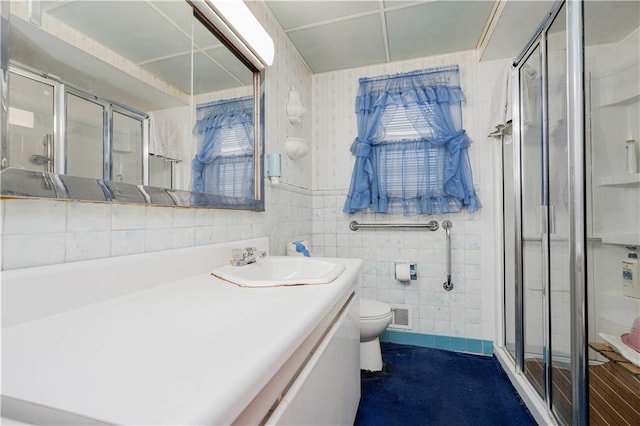 full bath featuring vanity, visible vents, a stall shower, tile walls, and toilet