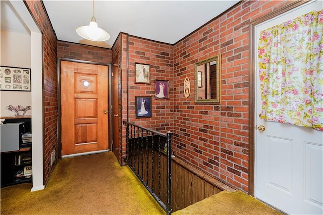 foyer with light colored carpet and brick wall