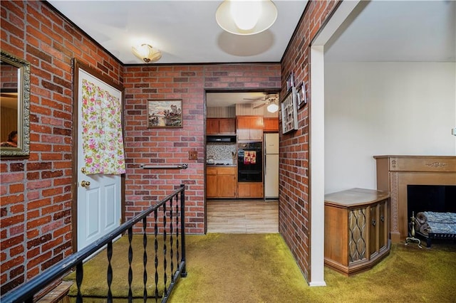 hall with an upstairs landing, carpet, and brick wall