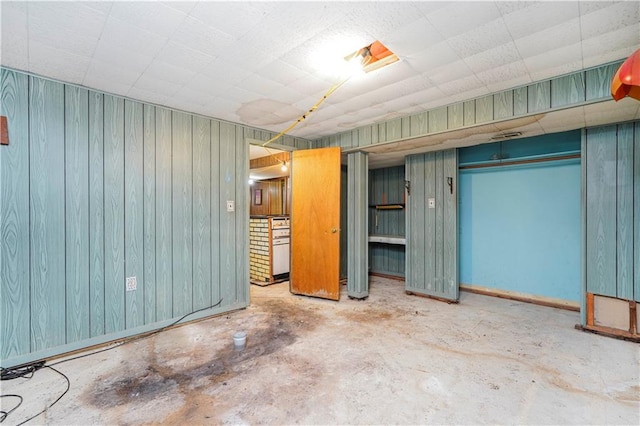 interior space with wood walls and concrete flooring