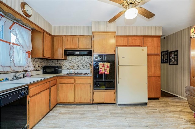 kitchen featuring a warming drawer, black appliances, a sink, under cabinet range hood, and light countertops