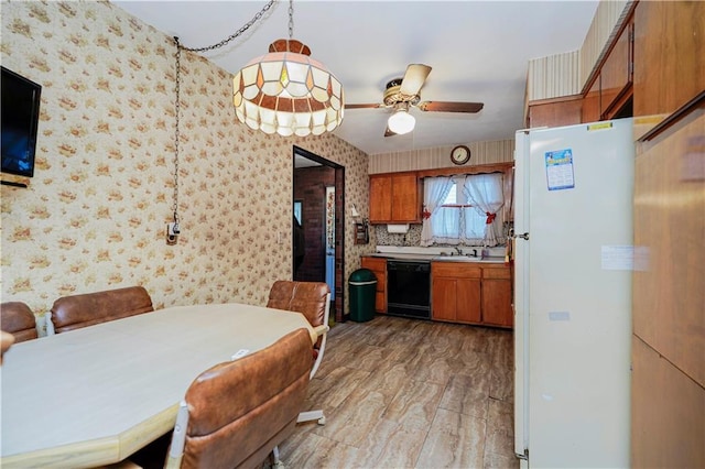 dining area with wallpapered walls, light wood-style flooring, and a ceiling fan