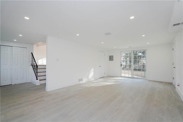 unfurnished living room featuring visible vents, baseboards, stairway, recessed lighting, and light wood-style floors