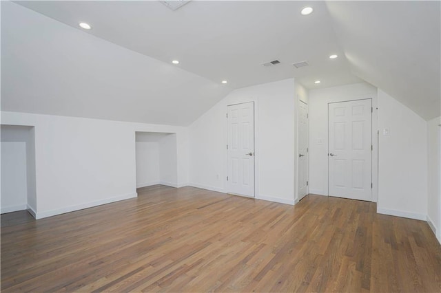 bonus room with visible vents, recessed lighting, lofted ceiling, and wood finished floors