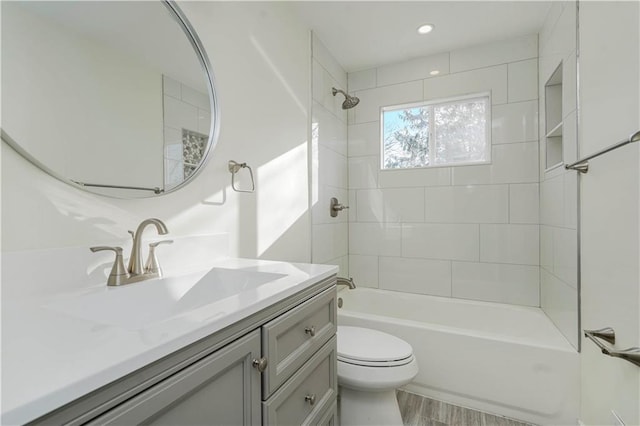 bathroom featuring vanity, toilet, and shower / washtub combination
