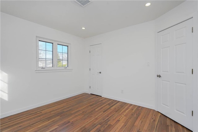 spare room featuring recessed lighting, visible vents, baseboards, and hardwood / wood-style floors