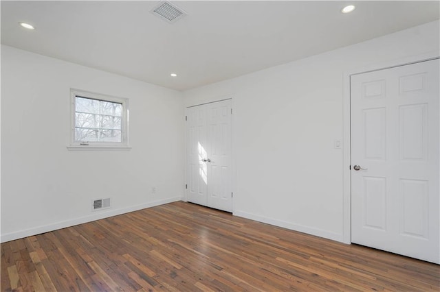 empty room with hardwood / wood-style flooring, recessed lighting, baseboards, and visible vents