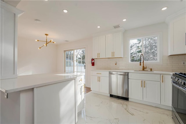 kitchen featuring a sink, light countertops, backsplash, and stainless steel appliances