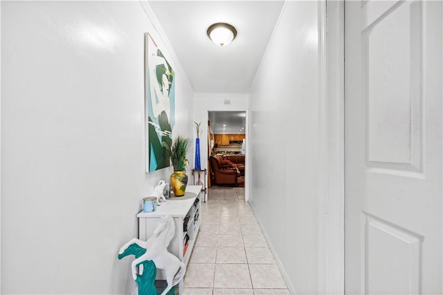 hall with light tile patterned floors and crown molding