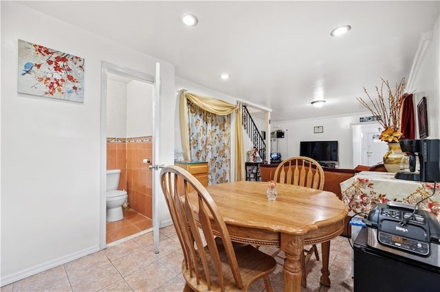 dining area featuring light tile patterned floors, stairway, tile walls, and recessed lighting