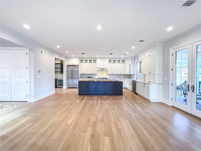 kitchen featuring visible vents, light wood-type flooring, appliances with stainless steel finishes, french doors, and white cabinets