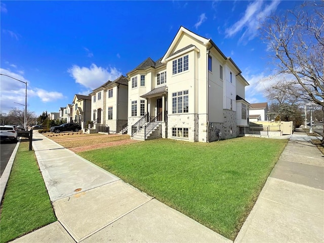 view of front of house featuring a residential view, stucco siding, and a front lawn