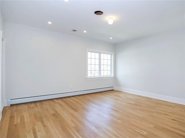 empty room featuring visible vents, a baseboard heating unit, recessed lighting, light wood finished floors, and baseboards