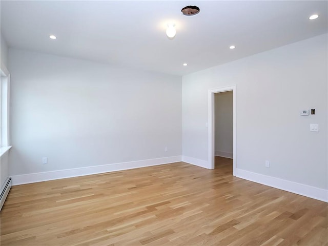 unfurnished room featuring recessed lighting, baseboards, a baseboard heating unit, and light wood-style floors