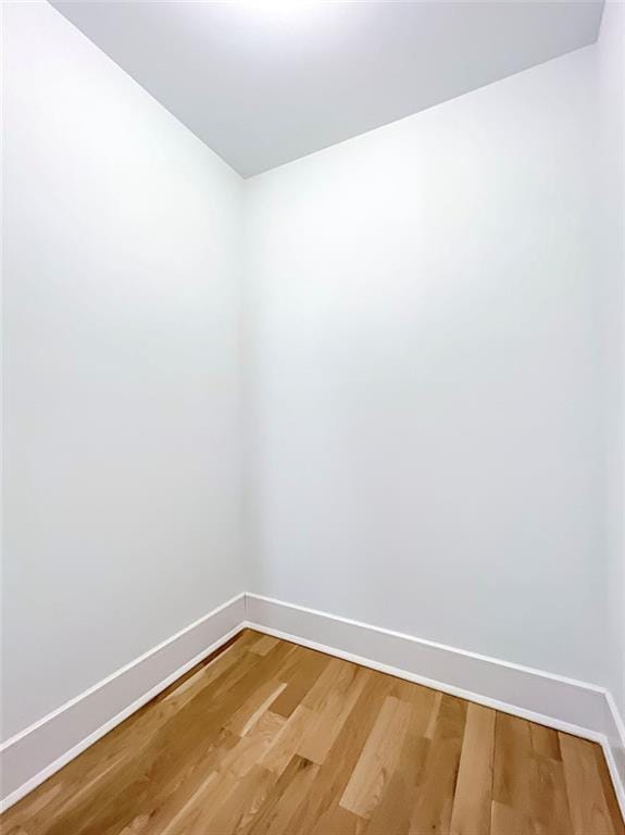 unfurnished room with baseboards and light wood-type flooring