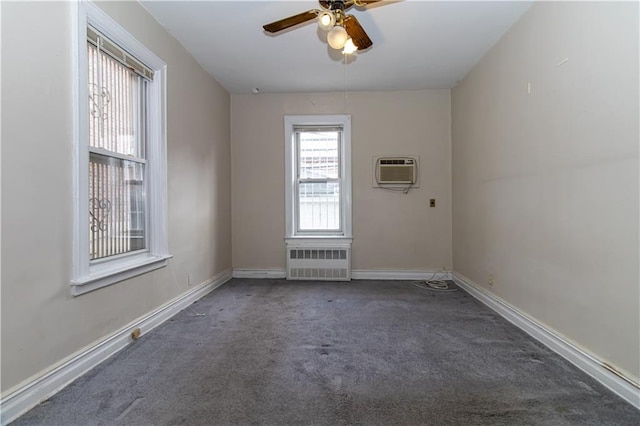 spare room with a ceiling fan, carpet, baseboards, radiator heating unit, and an AC wall unit