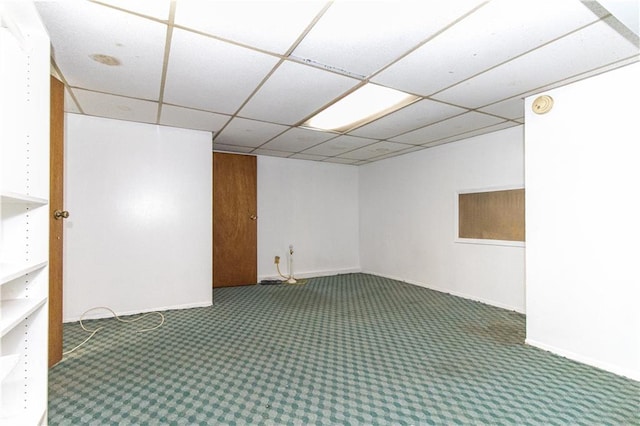 carpeted empty room with a paneled ceiling and baseboards