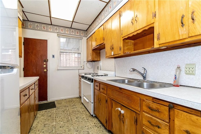 kitchen featuring a sink, tasteful backsplash, white range with gas stovetop, and light countertops