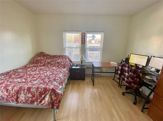 bedroom featuring light wood-style floors and radiator heating unit