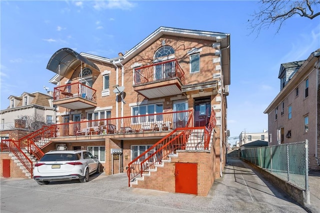 townhome / multi-family property with stairway and brick siding