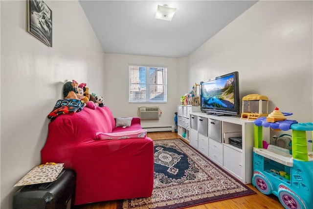 interior space with baseboard heating, a wall mounted AC, and wood finished floors