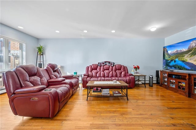 living room featuring recessed lighting, a baseboard heating unit, and light wood-style flooring