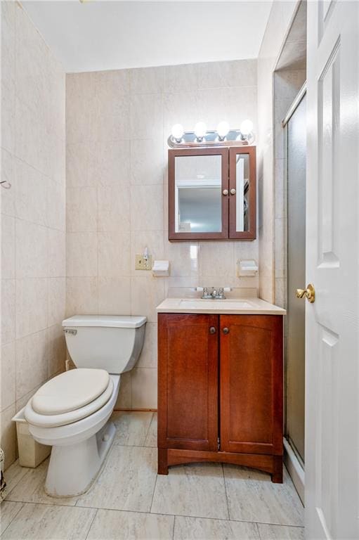 full bathroom with vanity, toilet, tile walls, and a shower stall